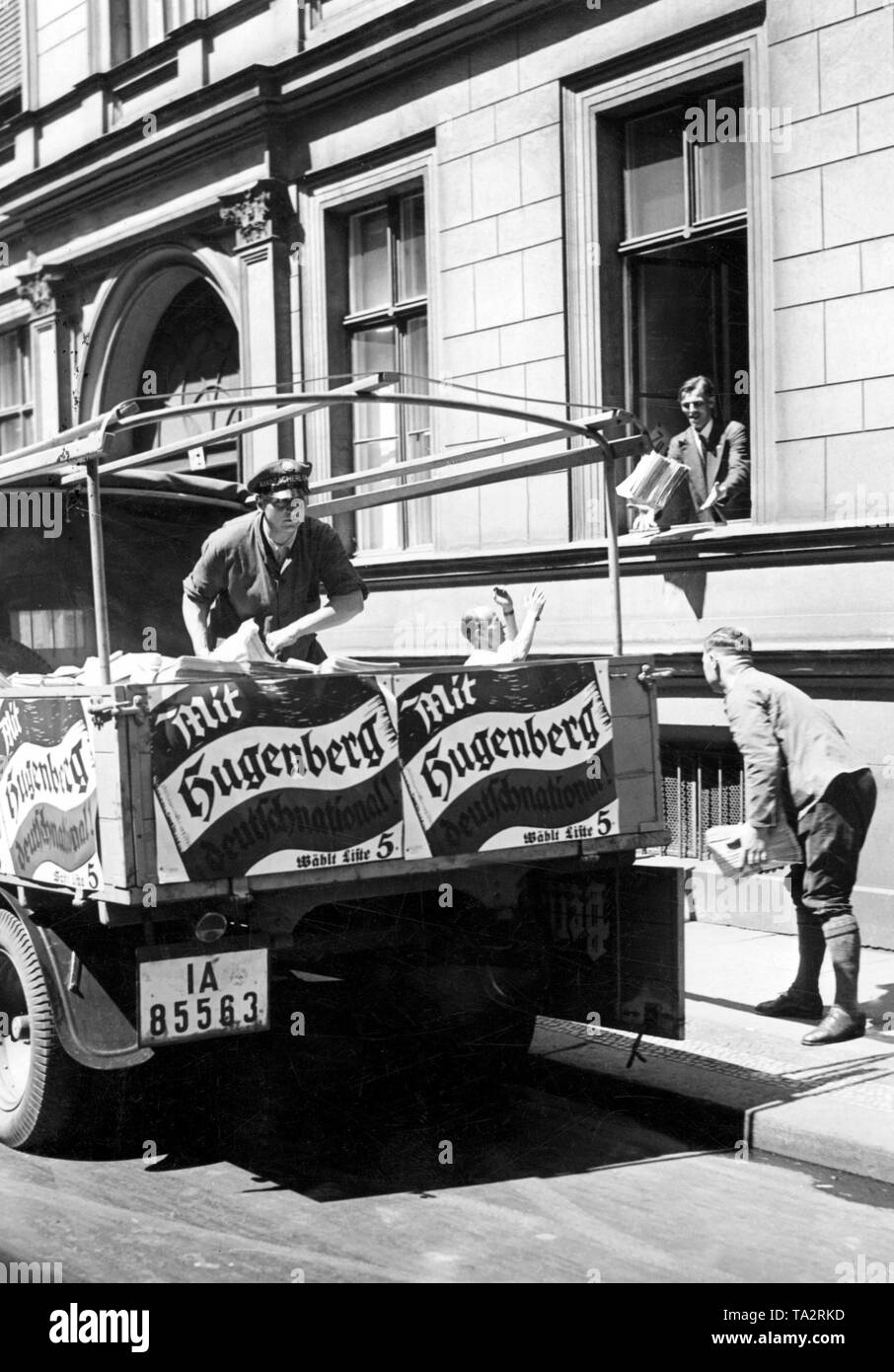 Unloading of advertising brochures for the Reichstag election in front of the office of the German National People's Party. The car is equipped with election posters, on which stands 'With Hugenberg German National!'. The Scherl Verlag provides these printed materials in large quantities. Stock Photo