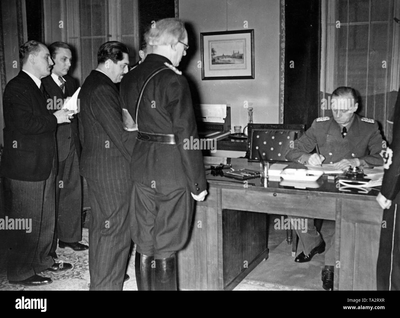 Joachim von Ribbentrop (right) signs the German-Slovakian Protection Treaty. At the desk stand the Slovak Prime Minister Vojtech Tuka (2nd from right) and Minister Ferdinand Durcansky (3rd from right). In March 1939, the Slovak state became independent under Hitler's pressure. The treaty is signed at the Foreign Office in Berlin. Stock Photo