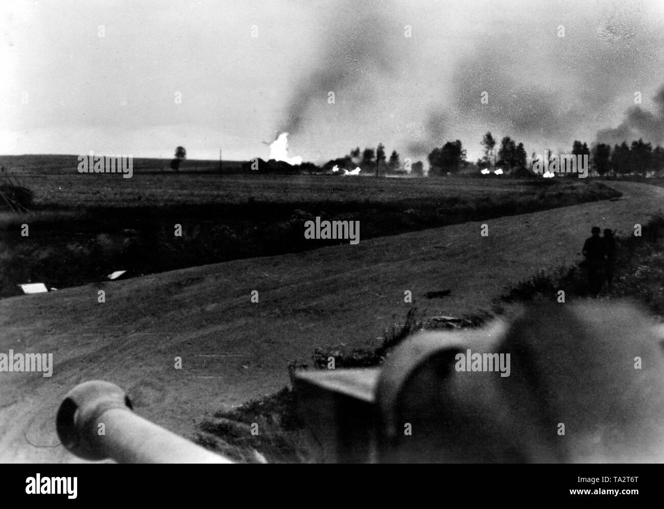 View of a burning village as seen from a German cannon on the Eastern Front. Photo of the Propaganda Company (PK): war correspondent Dreyer. Stock Photo