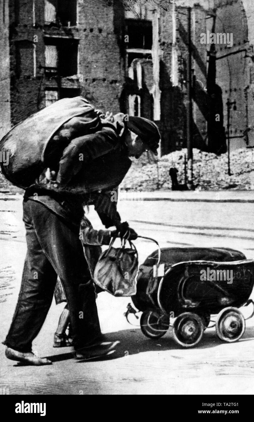 A woman and her child walk through the destroyed Berlin with their last belongings. Stock Photo
