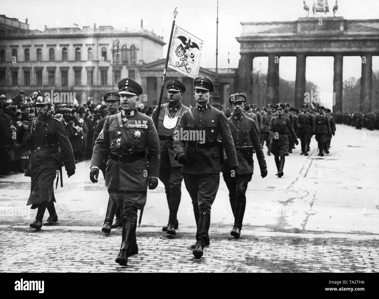 25,000 men of the 'Stahlhelm, Bund der Frontsoldaten' are marching to Schlossplatz from the Siegessaeule (Victory Column) through the Brandenburg Gate (photo) on the day of the Reichstag election in Berlin. In the front, Theodor Duesterberg, second leader of the Stahlhelm. On the left, a policeman. Stock Photo