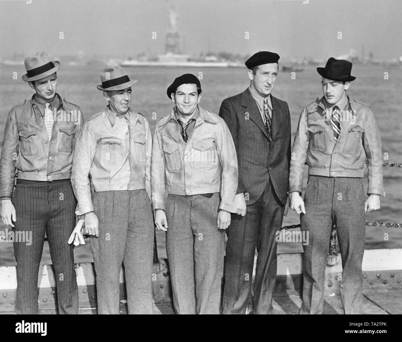 Photo of five American fighters of the Spanish Civil War from the International Brigade on the deck of the freighter 'Exiria' shortly before their arrival in the port of New York on March 17, 1940. The men were captured by Spanish national troops during the Spanish Civil War and had been released shortly before. From left to right: Rudolph O'Para, Clarence Blair, Cohn Haber, Anthony Kerhlicker, Larry Doran. In the background, the Statue of Liberty. Stock Photo
