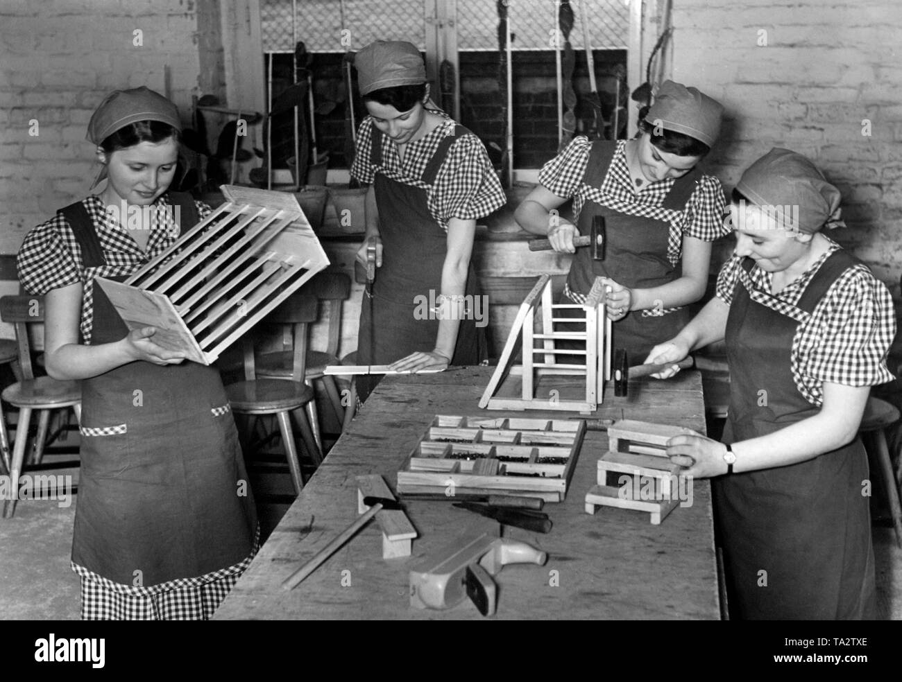 During their Landjahr, young girls learn the production and use of wooden household items made in a housekeeping school of the BDM in Berlin Lichtenberg. Stock Photo