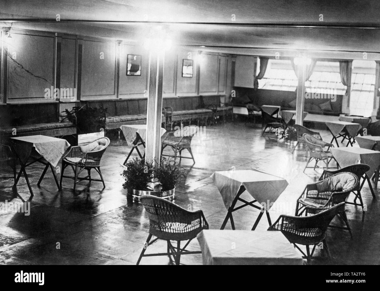 View of the spacious social hall of the English giant airship R 101, where the passengers could sit together at cozy tables. Stock Photo
