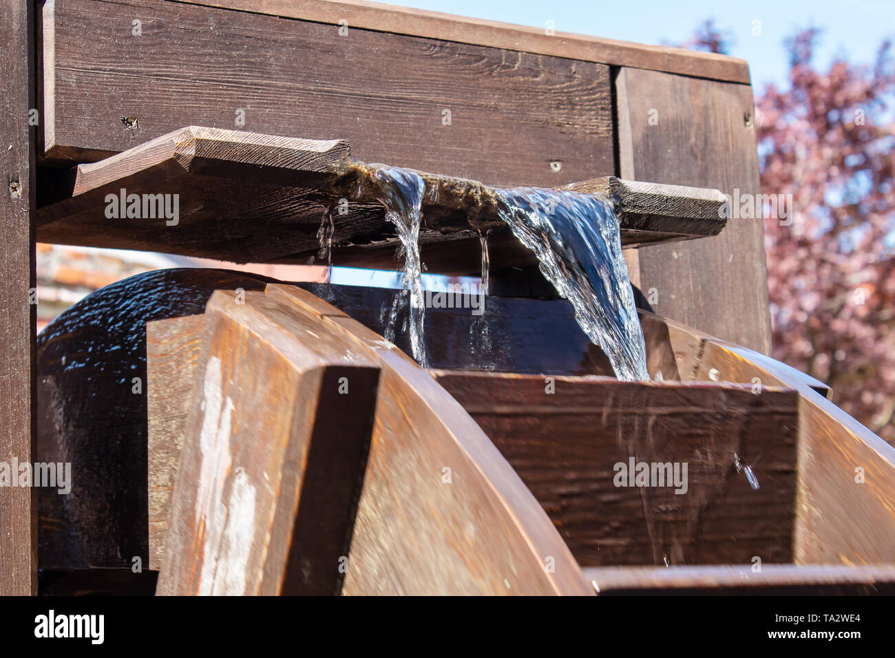 large wooden wheel rotating with water outdoor closeup on sunny day ...