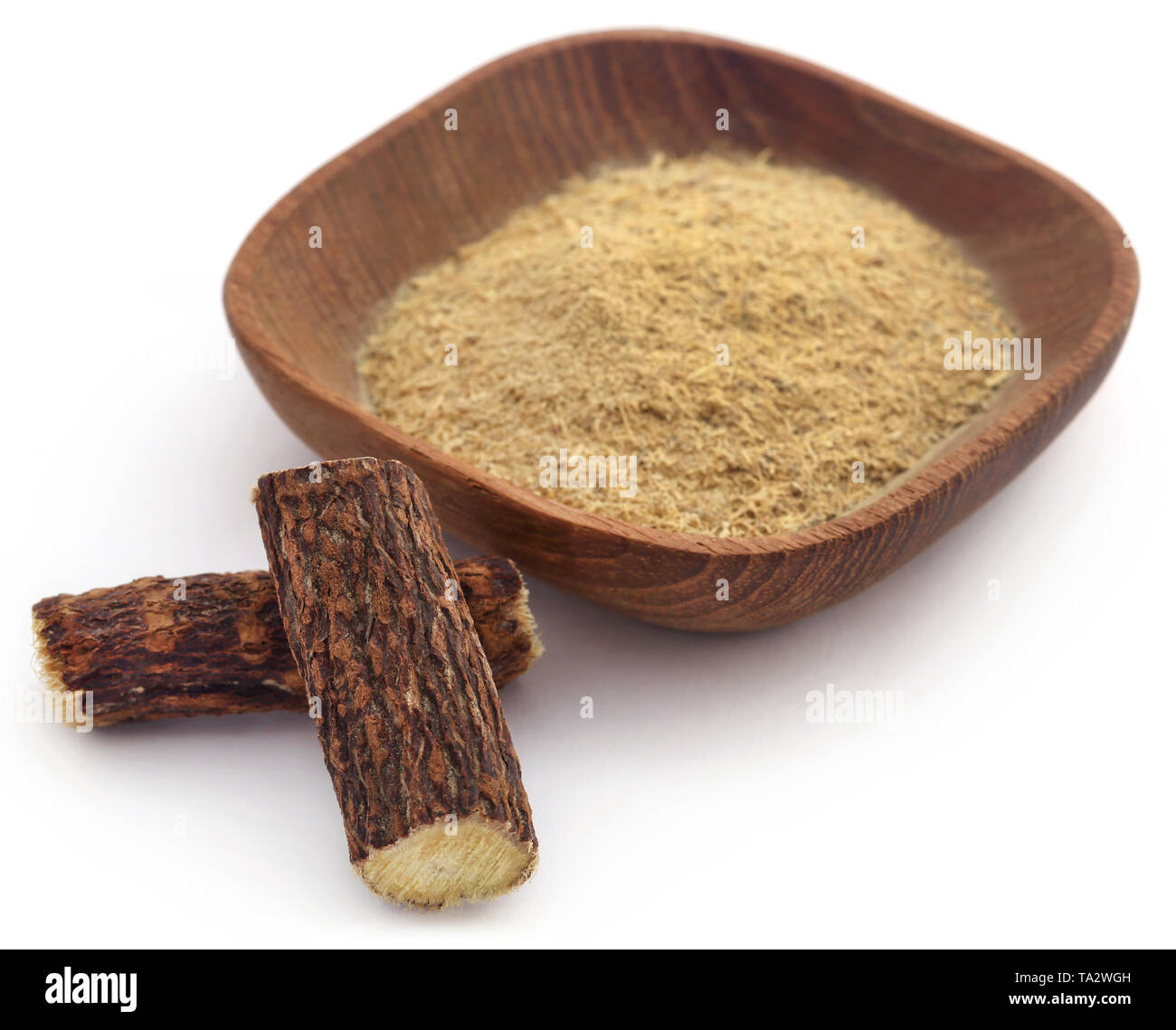 Liquorice stick and ground powder in a bowl over white Stock Photo Alamy