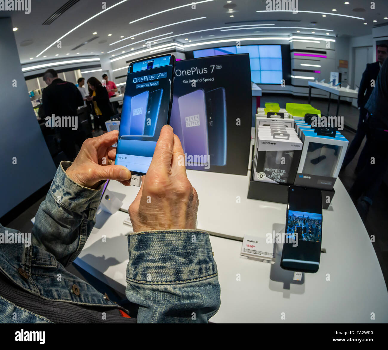 A visitor to a T-Mobile store in New York tries out the OnePlus 7 Pro smartphone on Thursday, May 16, 2019. The smartphone brand has a following which admires the smartphones for their features but with a lower price point than the iPhone or Samsung flagship devices.  (Â© Richard B. Levine) Stock Photo