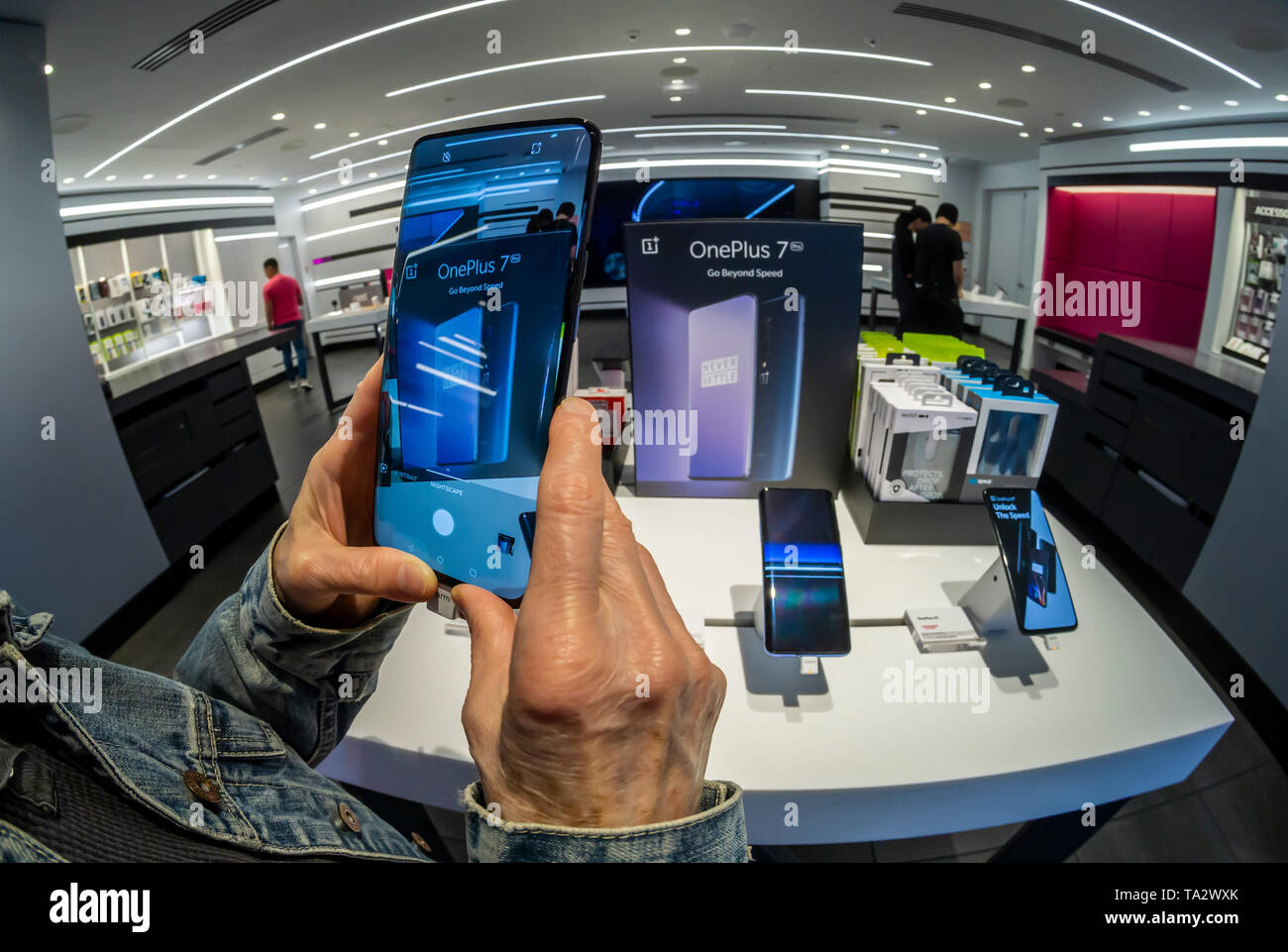 A visitor to a T-Mobile store in New York tries out the OnePlus 7 Pro smartphone on Thursday, May 16, 2019. The smartphone brand has a following which admires the smartphones for their features but with a lower price point than the iPhone or Samsung flagship devices.  (© Richard B. Levine) Stock Photo