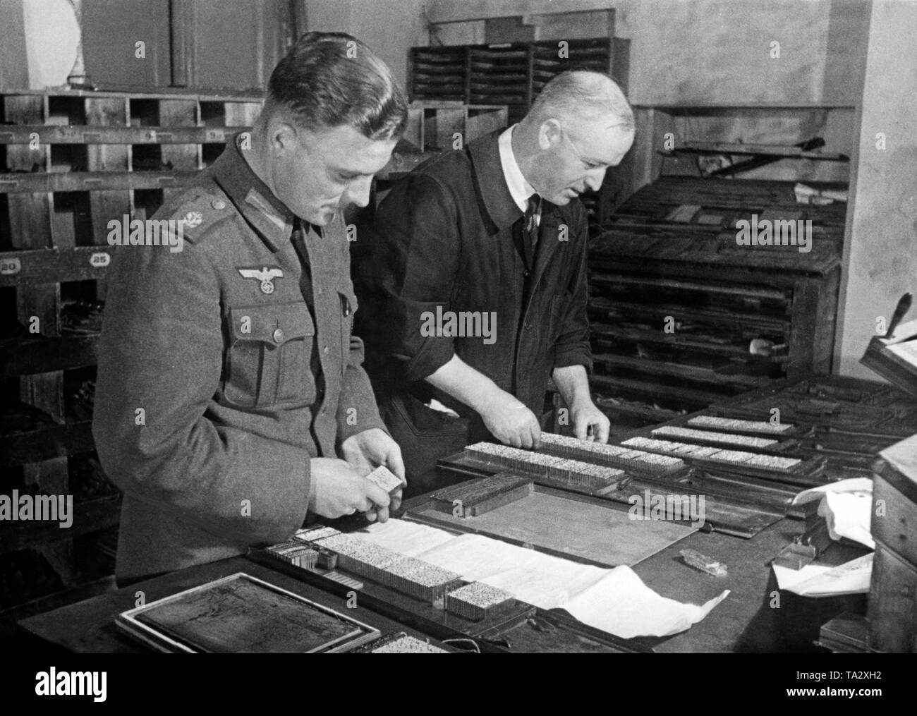 A military newspaper is typeset. On the left a soldier of the Navy. Photo of the Propaganda Company (PK): Dietrich Stock Photo