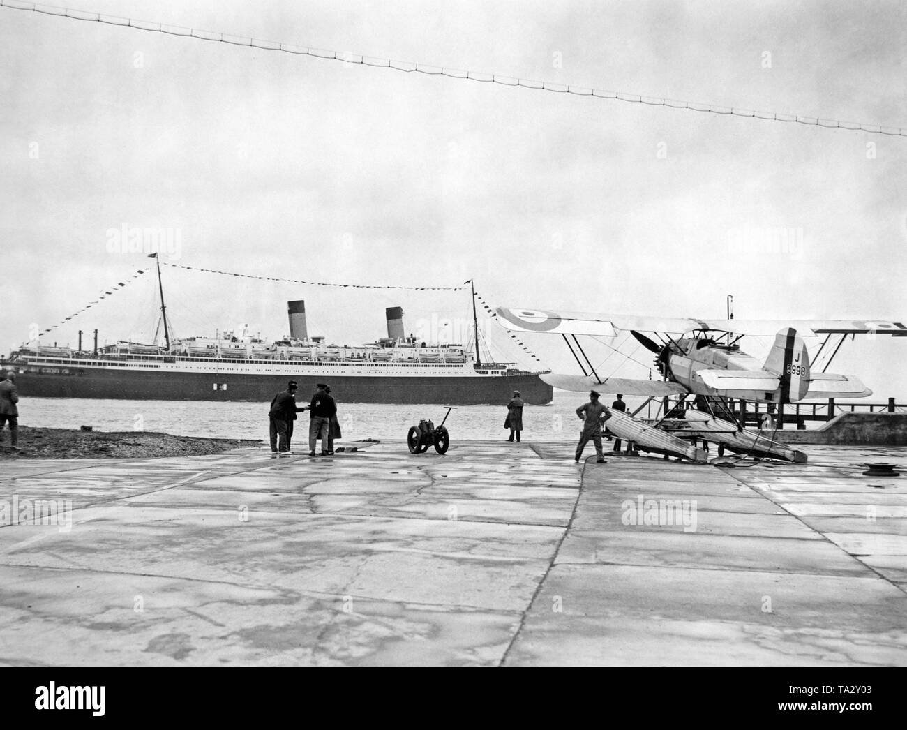 The ocean liner 'Homeric' of the White Star Line in front of Calshot Spit. In the foreground a plane participating in the Schneider Trophy. Stock Photo