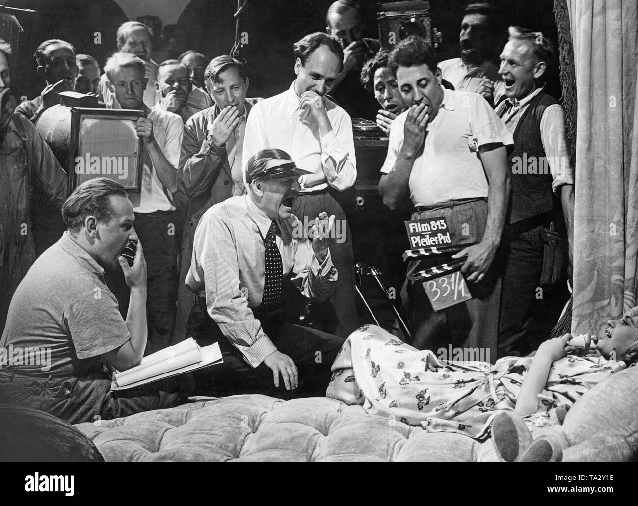 This recording shows director Ralph Arthur Roberts (middle sitting) and his film crew trying to infect a young actress with their yawning. Stock Photo