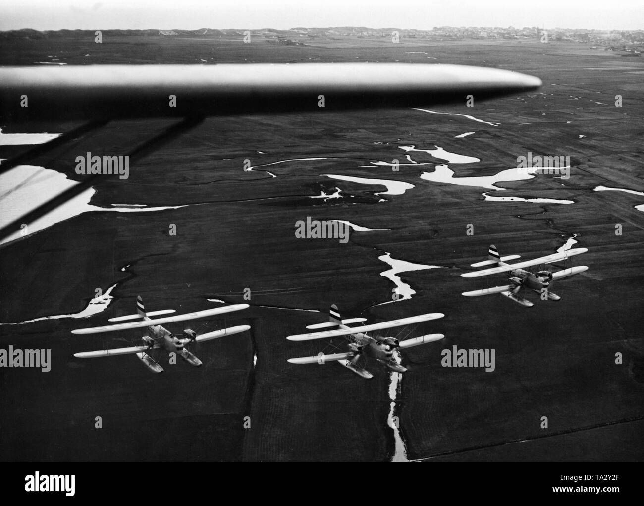 A formation of 3 two-engine multi seat combat aircrafts fly over an area of the Wadden Sea. These are Heinkel He 59 aircrafts. Stock Photo