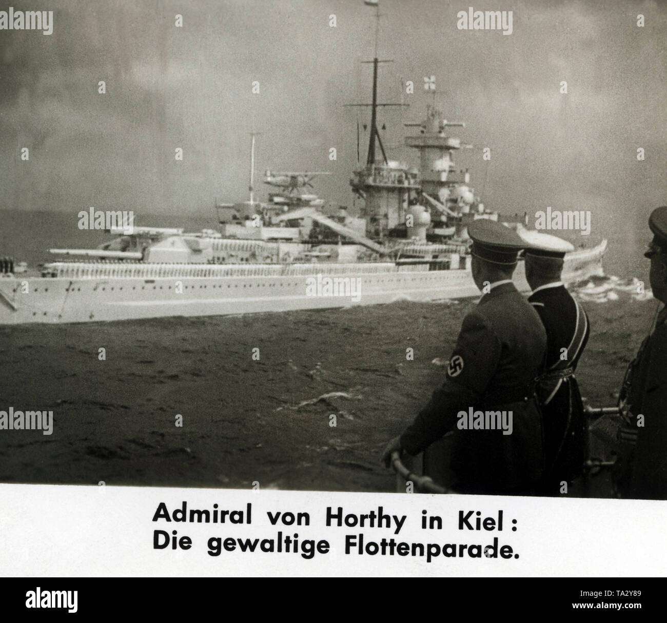 Fleet review in honor of the visit of Adolf Hitler and his guest, Admiral Horthy, the Regent of Hungary. The picture shows the passing battleship "Gneisenau", the sailors are standing in parade formation. The fleet parade took place near the Kiel Fjord. The picture shows Adolf Hitler and Horthy, it is a filmstill from a Ufa-Wochenschau ( Weekly Review). Stock Photo