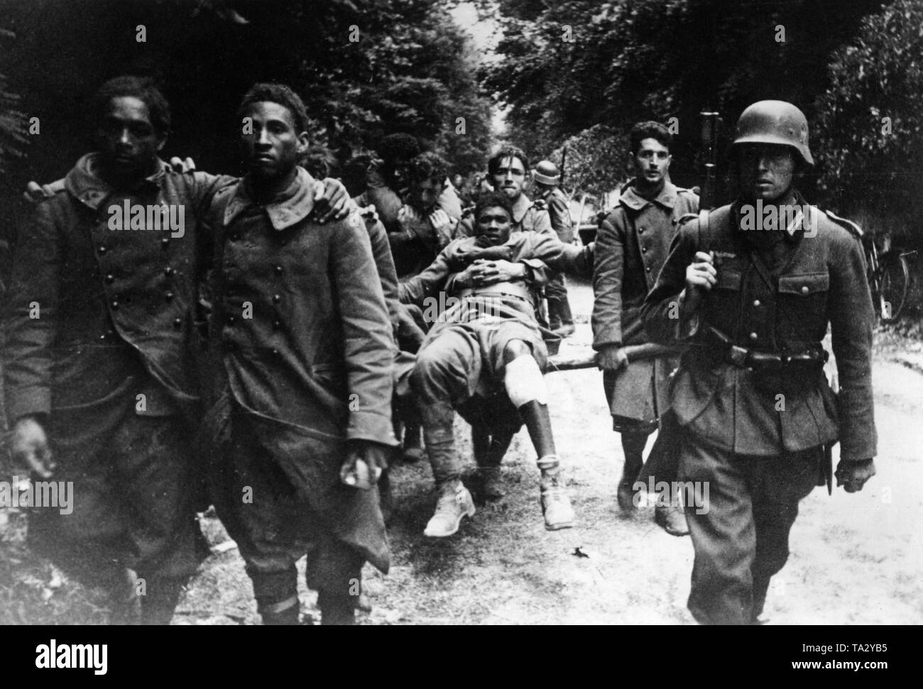 A German soldier supervises the return transport of French soldiers, partl of them members of colonial regiments. Photo: Dietrich. Stock Photo