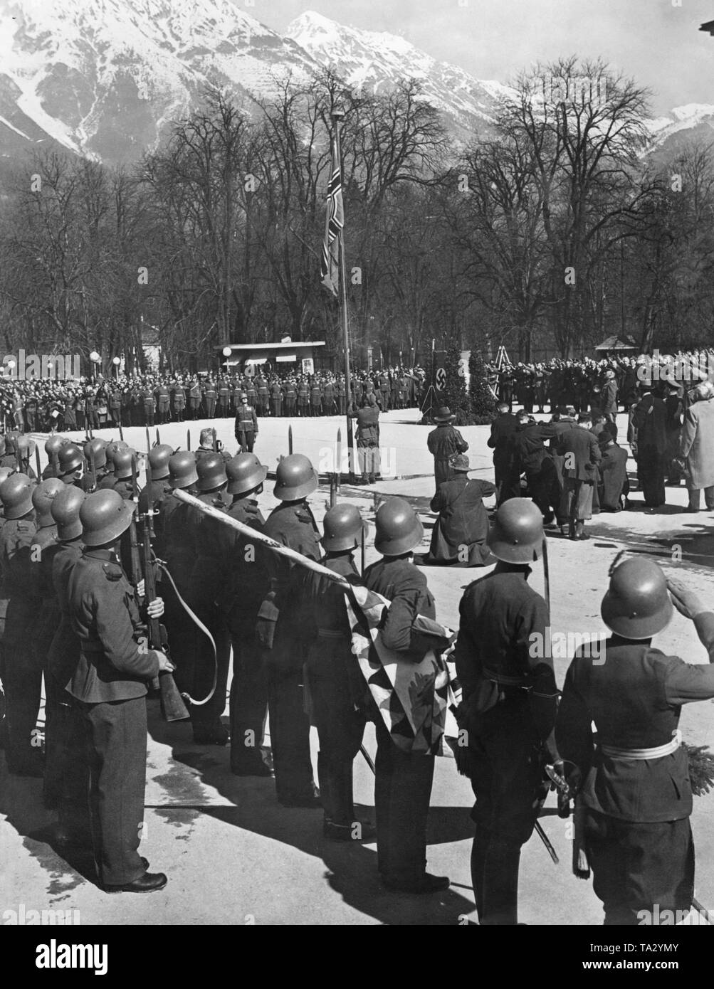 The Reichskriegsflagge is hoisted on the Adolf-Hitler-Platz in Vienna on the occasion of the swearing-in of the Tiroler Jaeger-Regiment to Adolf Hitler. Stock Photo