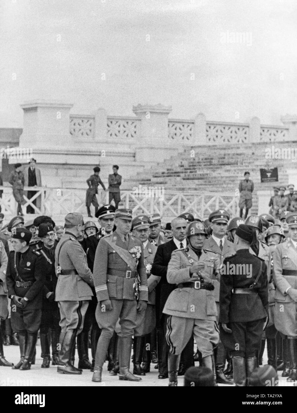 In front of the 'Altar of the Fatherland' (Monumento Nazionale a Vittorio Emmanuele II)  the Duce Benito Mussolini (center, with steel helmet), members of the fascist militia and foreign guests commemorate the fallen Italian legionaries of the Spanish Civil War  in Rome on October 31. Mussolini honors a fascist militiaman (Blackshirt). Behind the Duce from left to right : Viktor Lutze (Chief of Staff of the SA), Gauleiter Robert Wagner, Minister of the Reich Rudolf Hess, Marschall Emilio de Bono (with steel helmet) and Minister of the Reich Hans Frank (right edge of the picture). Stock Photo