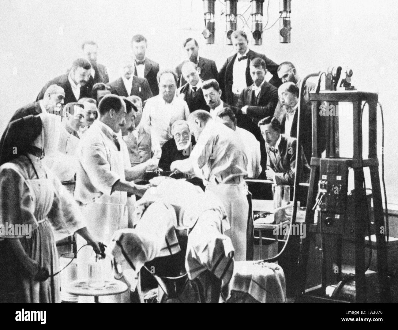 German pathologist Rudolf Virchow (middle, in a dark suit) during a cranial surgery in a hospital in Paris. Stock Photo