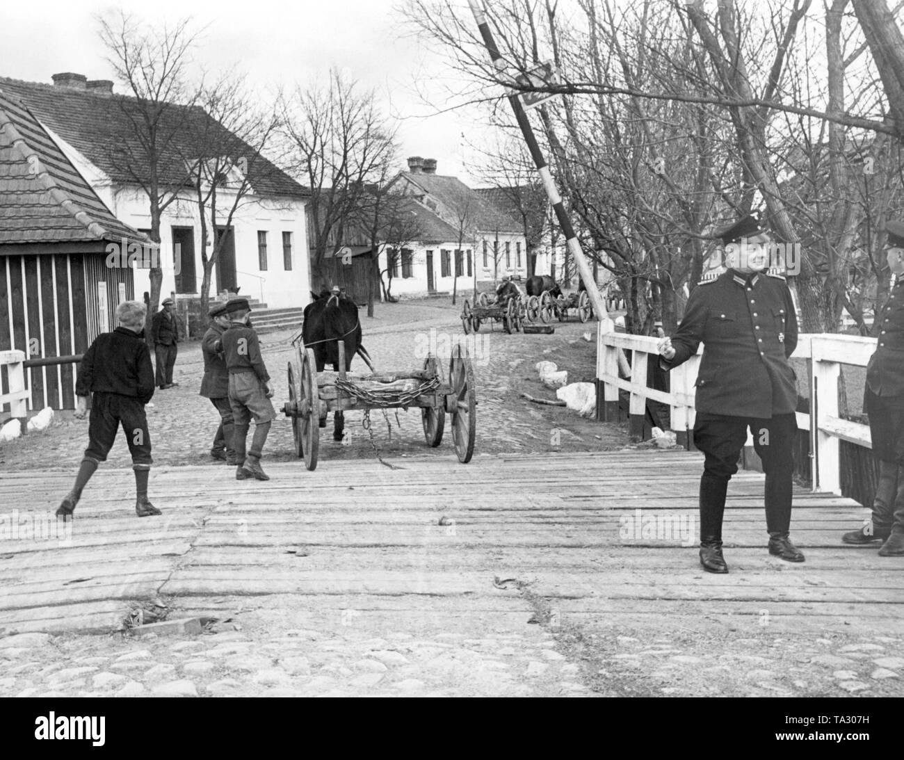 Border crossing at the German-Polish border in Bischofswerder, on the bridge are border guards, empty wagons are pulled by horses. Stock Photo