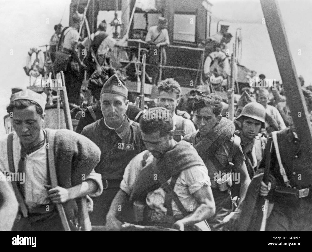Photo of Republican fighters waiting for their departure to Spain in a port in Mallorca after the Battle of the Balearics in September, 1936. In the background, a steamboat. In the foreground, a paramedic. Stock Photo