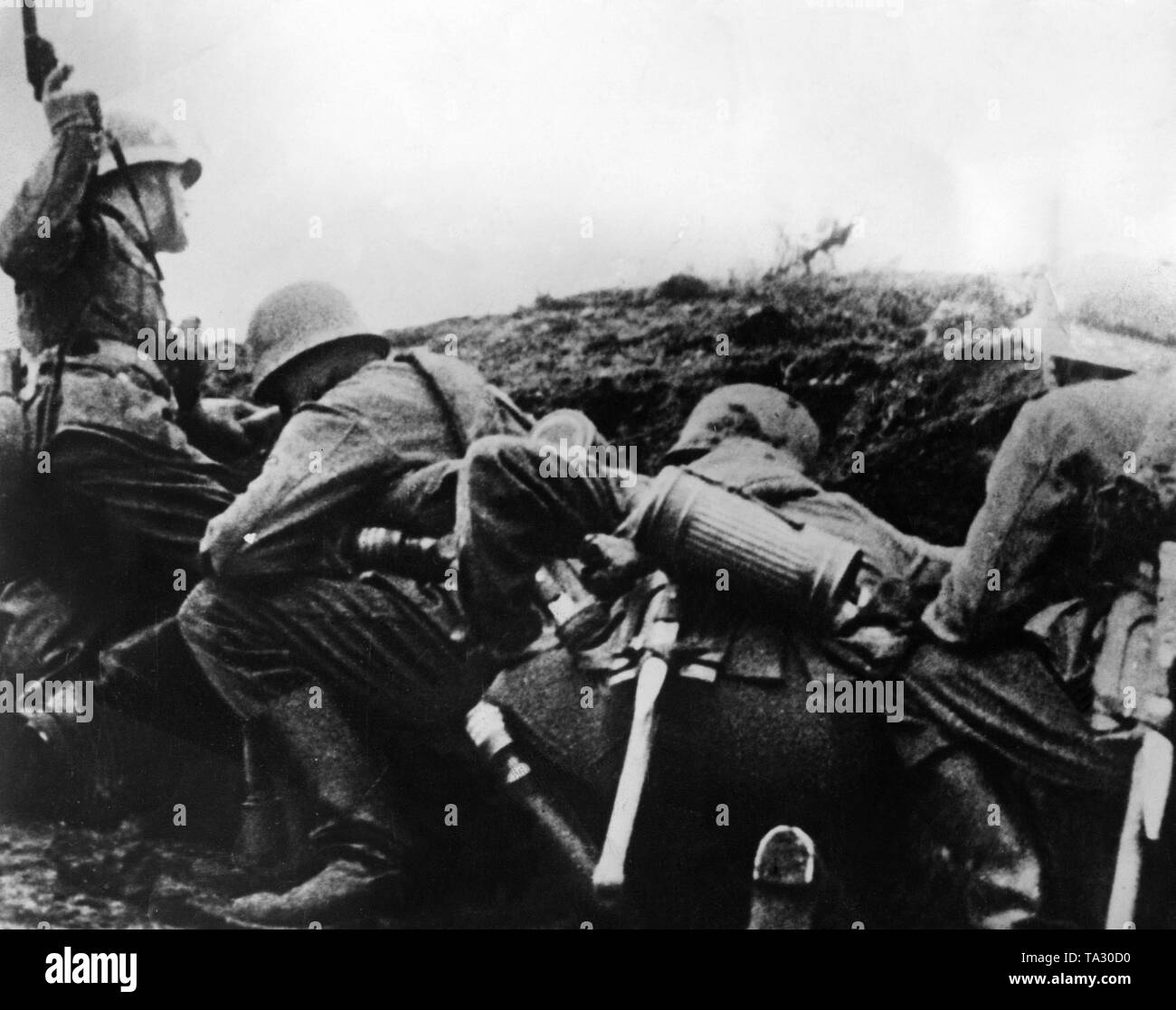 A German battalion in action. With the light gun the sergeant (left) shows to his own combat leaders which position was reached. Stock Photo