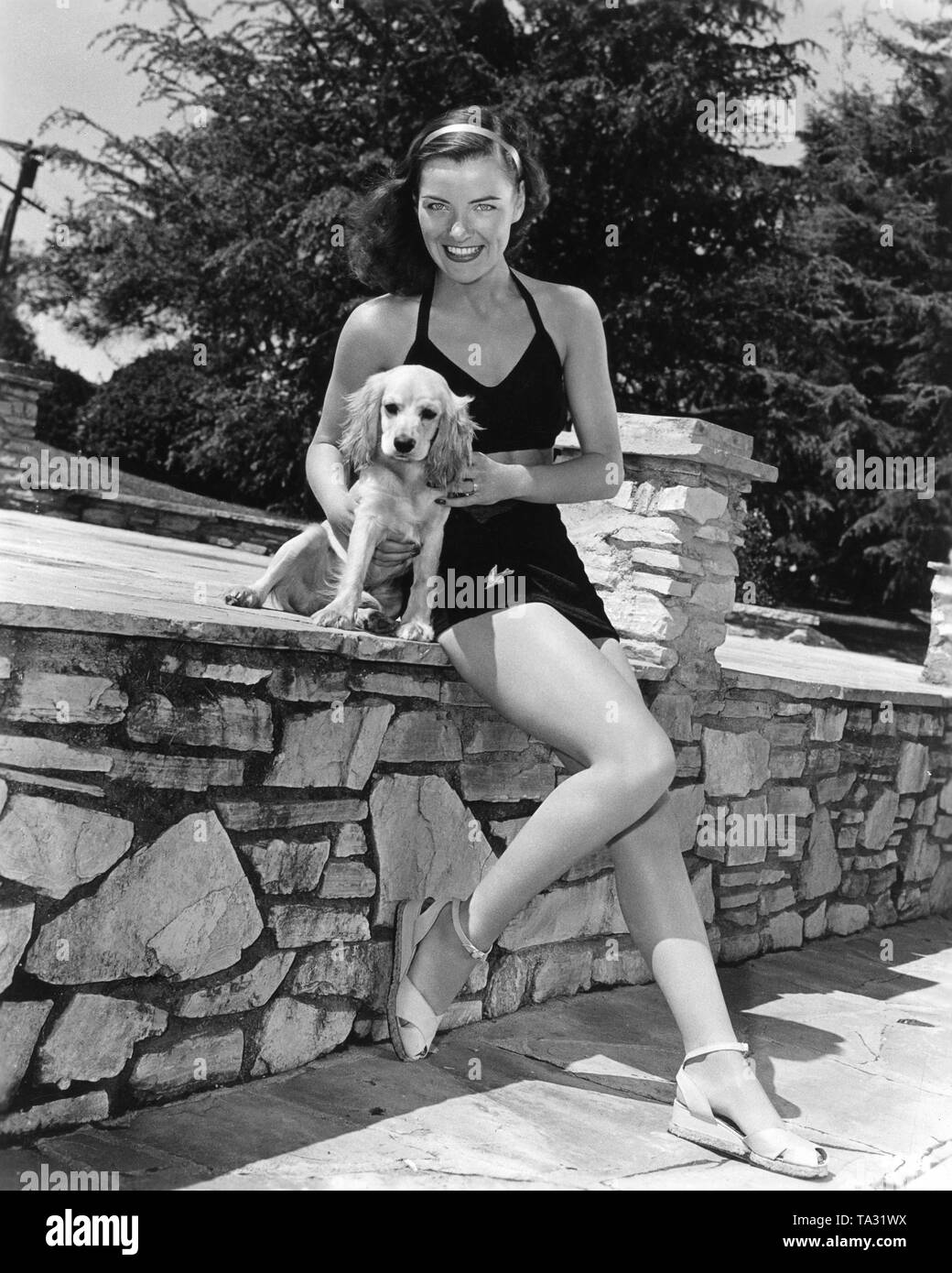 ELLA RAINES circa 1944 pin-up publicity photo with dog Universal Pictures Stock Photo