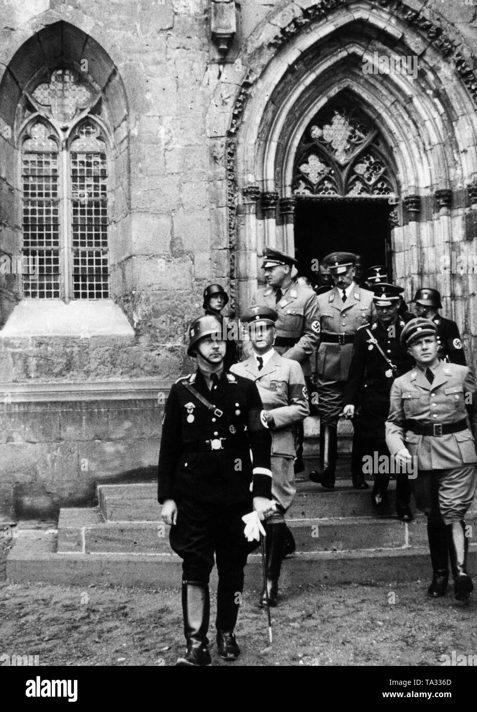 Reichsfuehrer-SS Heinrich Himmler, behind him Wilhelm Frick and Reichsleiter Martin Bormann (right) in front of the entrance of the Quedlinburger Dom (Stiftskirche St. Servatius), in which is located the grave of the German king and emperor of the Holy Roman Empire, Henry I (919-936 ) from the Liudolfinger (Ottonen) family. Henry I was venerated by Himmler especially as a founder of the empire and defender of Slavs. Himmler considered himself a reincarnation of the king and was personally present at the annual celebrations on July 2nd Stock Photo