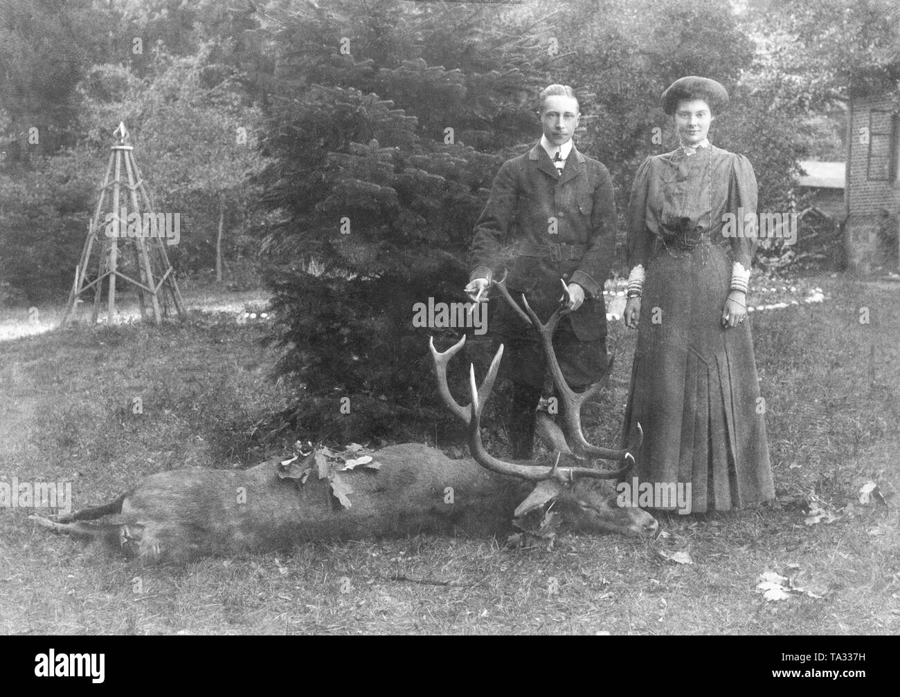 Crown Prince Wilhelm of Prussia (l.) and his wife Crown Princess Cecilie (r.) on a hunting stay in the forester's house of Neu Ramuck. The couple is pictured with a deer, probably shot by Crown Prince Wilhelm. Stock Photo