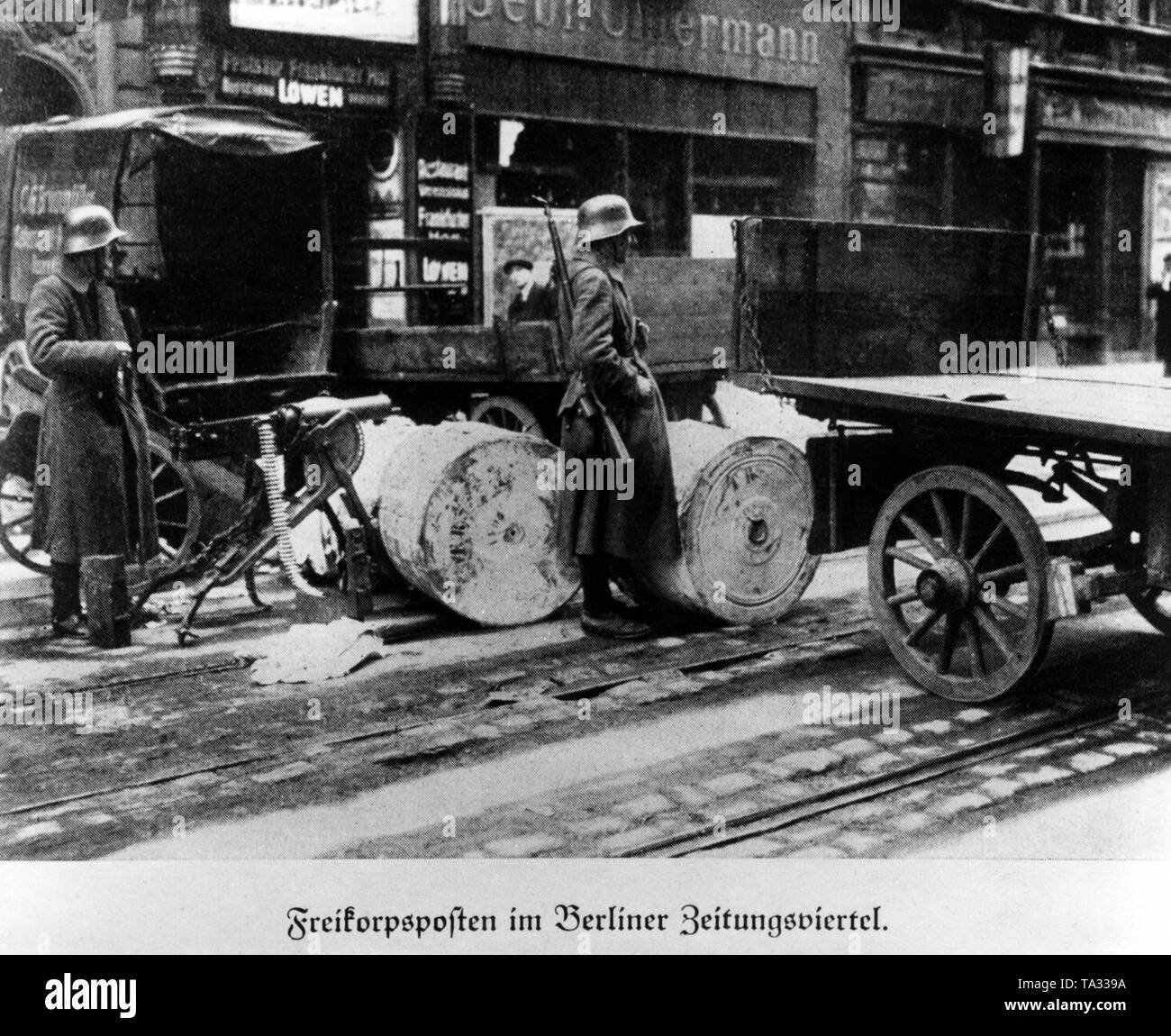 Loyalist Freikorps units guard a street with a barricade in Berlin's Zeitungsviertel against insurgents of the January Uprising. During the unrest there were armed conflicts between left-wing revolutionaries and government-loyal Freikorps units. Stock Photo
