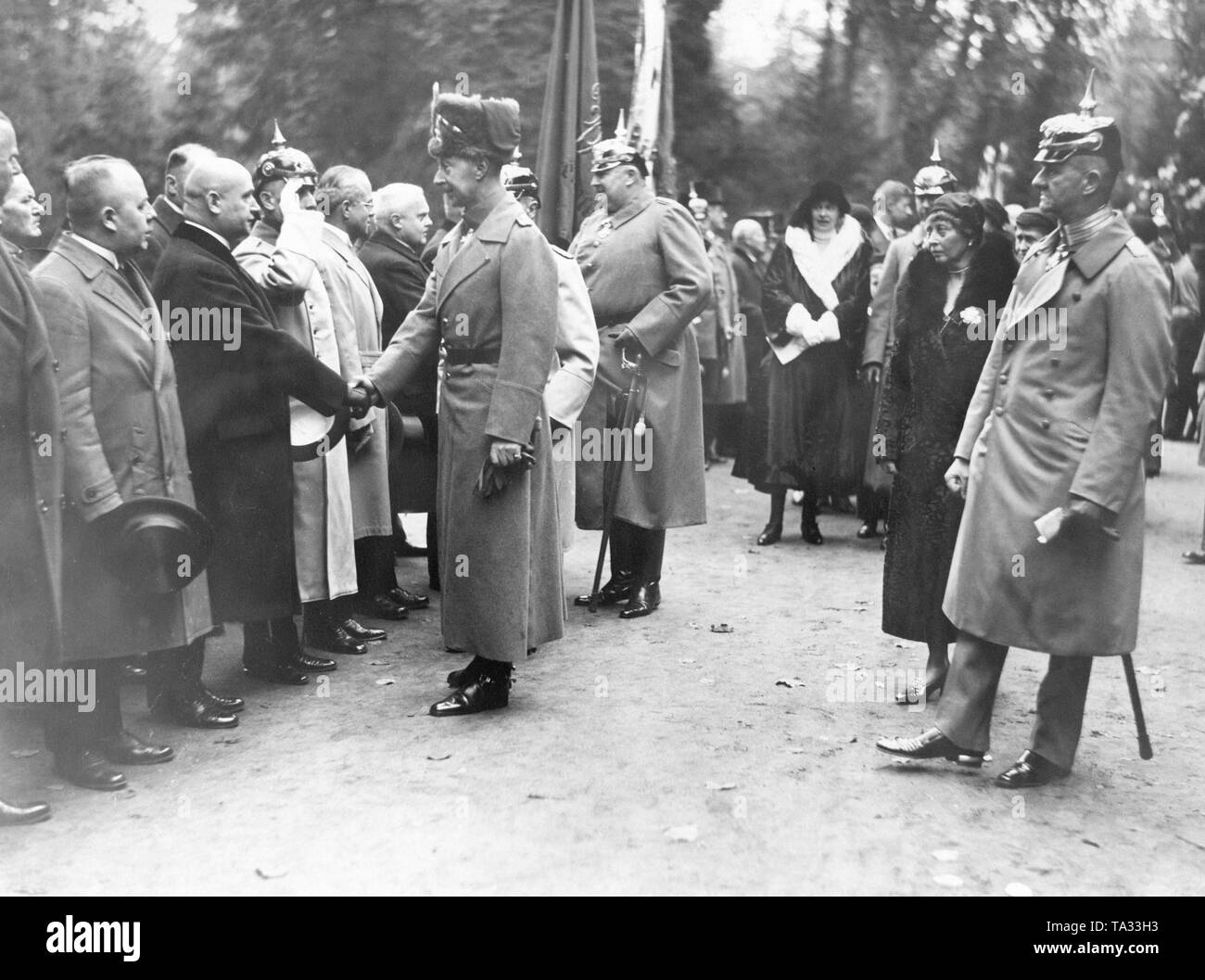 The Crown Prince in a hussar uniform (left front) shakes hands with a representative of the Patriotic Federations. Behind him (with spiked helmet and saber in hand) is his brother Prince Eitel Friedrich of Prussia, who also welcomes members of the association. The wives of the two Prussian princes are also present. Further behind in the black coat with white collar, Crown Princess Cecilie of Mecklenburg, in front (2nd from the right) also in black coat, the wife of Prince Eitel Friedrich, Sophie Charlotte of Oldenburg. Stock Photo