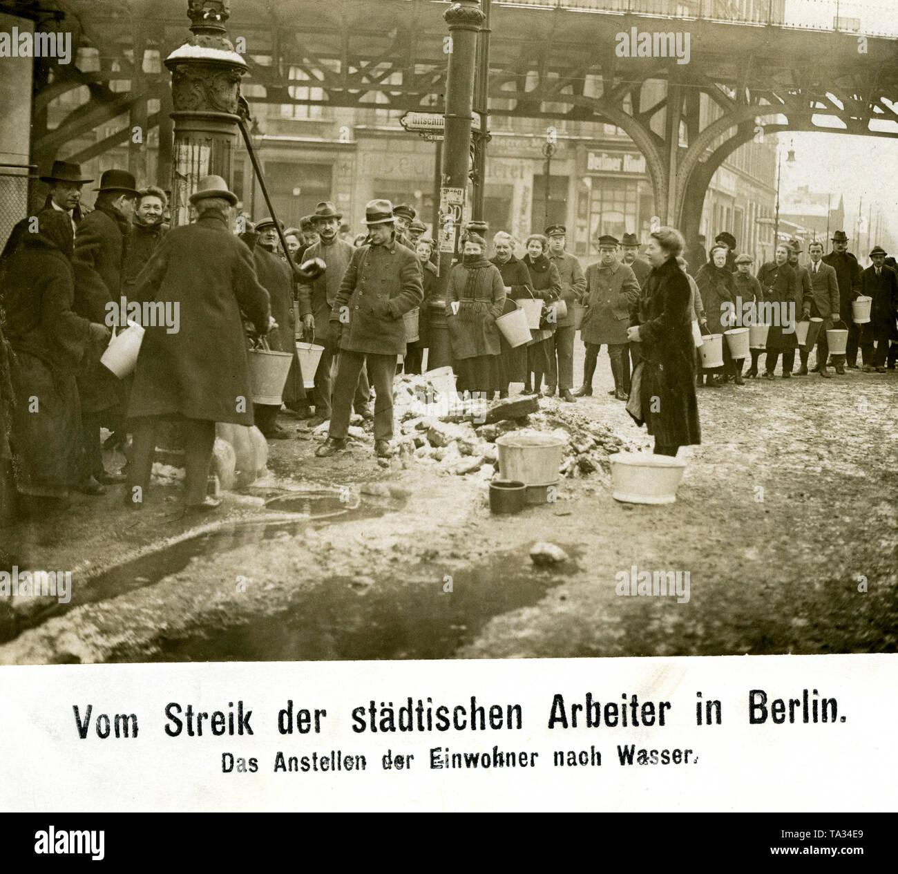 Since the strike of the urban workers also meant that the water supply failed, the inhabitants of Berlin were getting their water by means of the old water pumps of the city and many buckets and bowls. (undated photo) Stock Photo