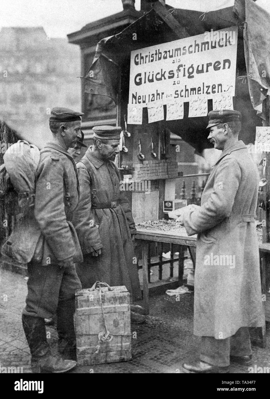 After arriving in Berlin two war returnees look at Christmas decorations at a booth on a Christmas market in Berlin. Stock Photo