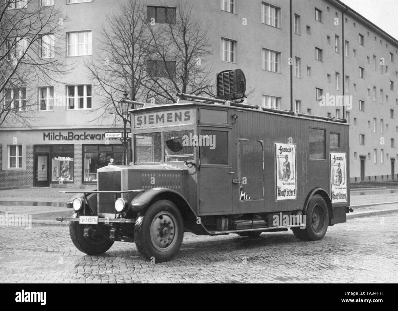 National Socialists campaign in the streets of Berlin with a truck with loudspeakers (Siemens brand). On the side walls the posters are explicitly addressed to women, so that they vote for Hitler. Stock Photo