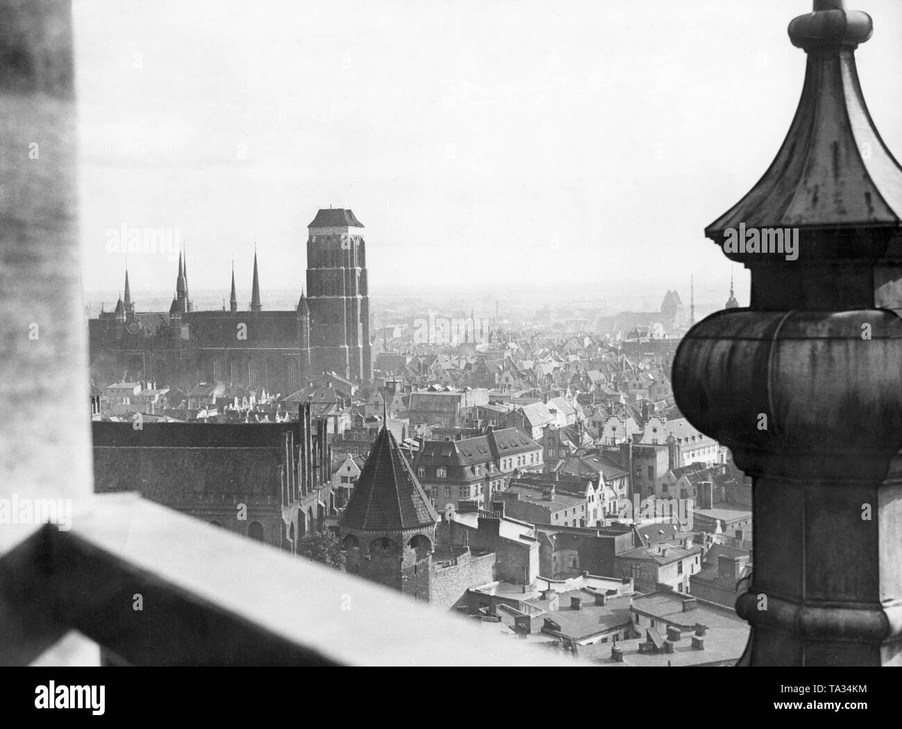 This photograph shows the view from St. Catherine's Church on St. Mary's Church. St. Catherine's Church is one of the oldest churches in Gdansk and was probably built at the end of the 19th century. The groundbreaking ceremony of St. Mary's Church took place in 1343 and the church was completed in 1502. It was built in Brick Gothic style. It is one of the largest brick churches north of the Alps and has place for 25,000 people inside. It houses the famous triptych 'The Last Judgment' by the painter Hans Memling. Stock Photo