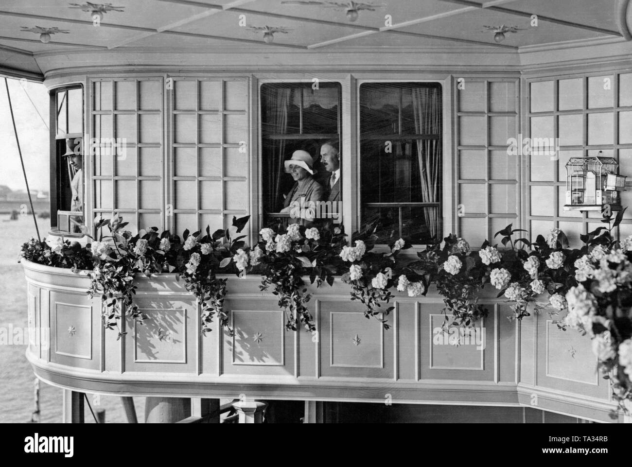 Two passengers of the HAPAG steamer 'New York' at the window of their cabin. Stock Photo