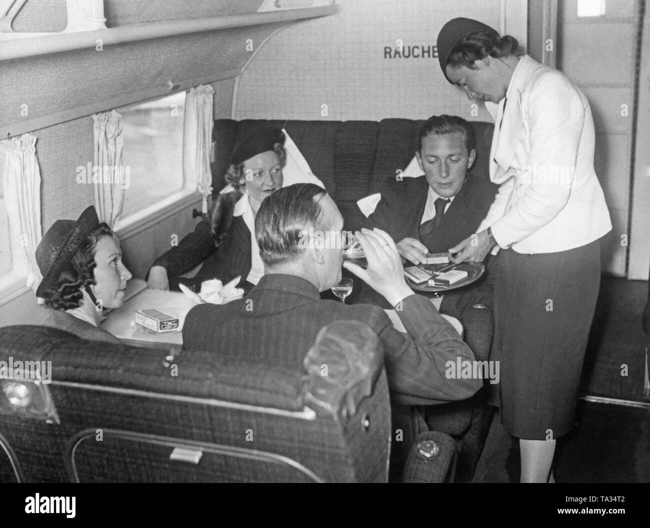 Passengers in the smoking compartment of a Focke-Wulf FW 200 'Condor' of the Deutsche Lufthansa. The aircraft was registered D-AETA, and its given name is 'Westfalen'. Stock Photo