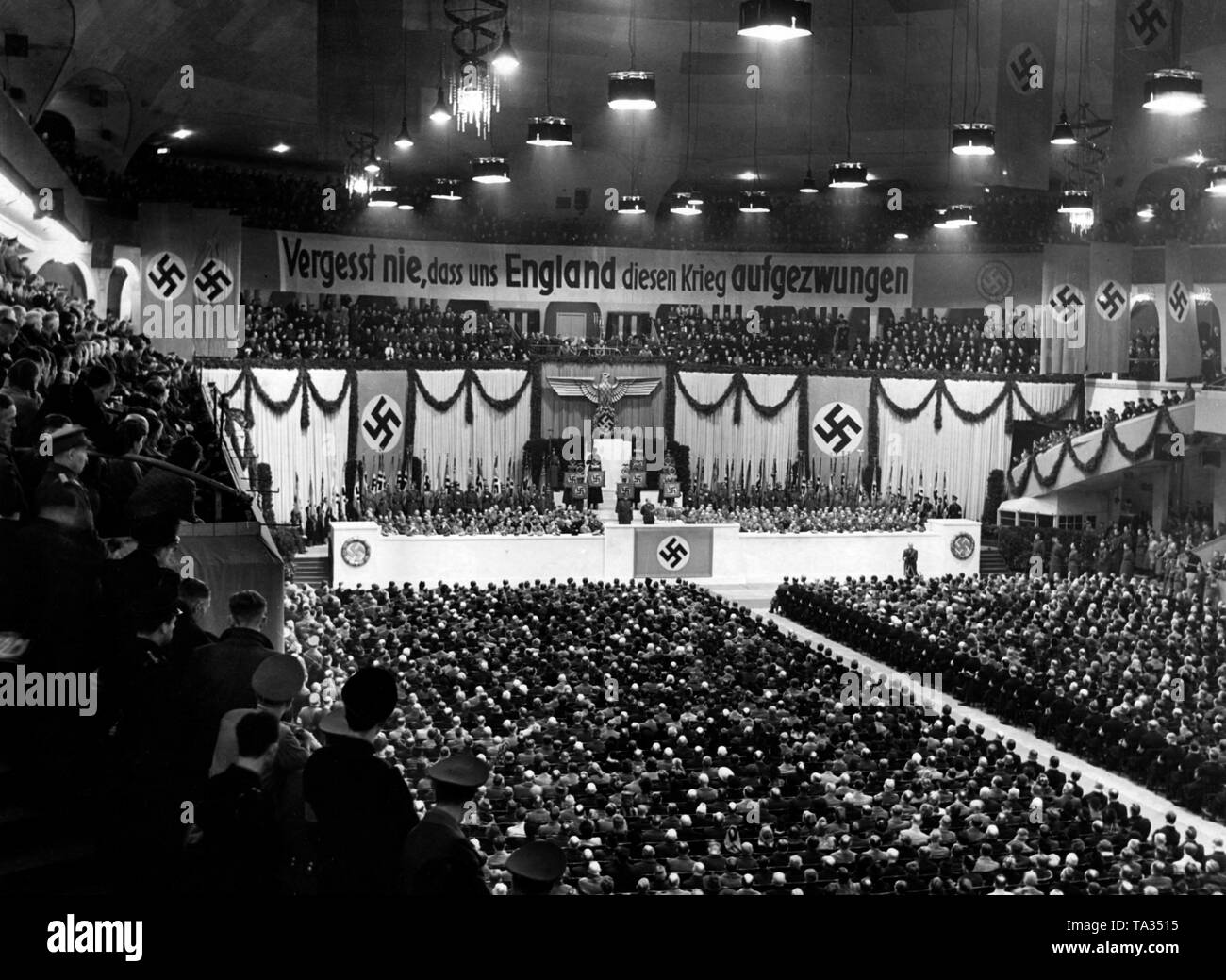 Minister of Propaganda Joseph Goebbels is giving a speech at a party rally of the Gau Berlin of the NSDAP in the Berlin Sportpalast. Above the rank there hangs a banner with the inscription 'Never forget that England has forced this war upon us'. Stock Photo