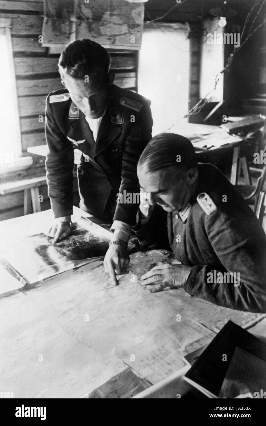 The Luftwaffe Forward Air Controller (left), here a lieutenant, presents a general staff officer, here a colonel, aerial photographs of the reconnaissance. The picture was taken at Gurodez, September 1941, on the eastern front. Photo: war reporter Ulrich. Stock Photo