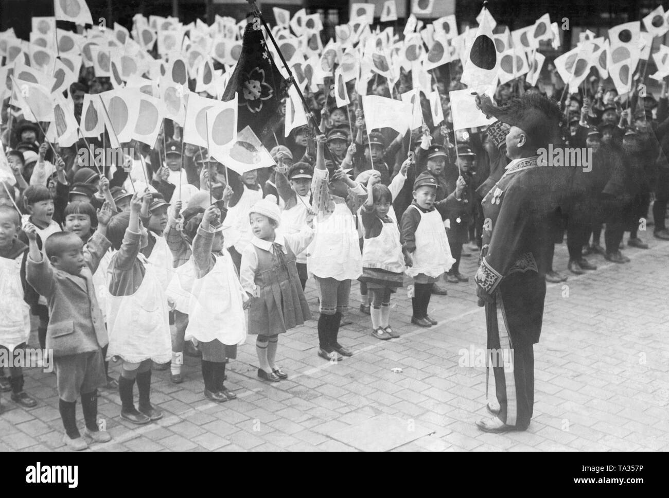 Schoolchildren stand in line with flags on November 10, 1928 at the coronation of the new Japanese emperor Hirohito in Kyoto. Stock Photo