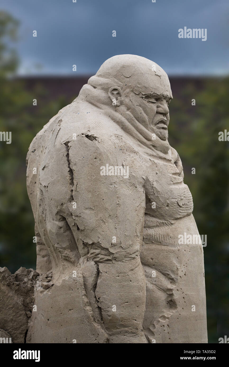 sand sculpture of a giant with dark background Stock Photo