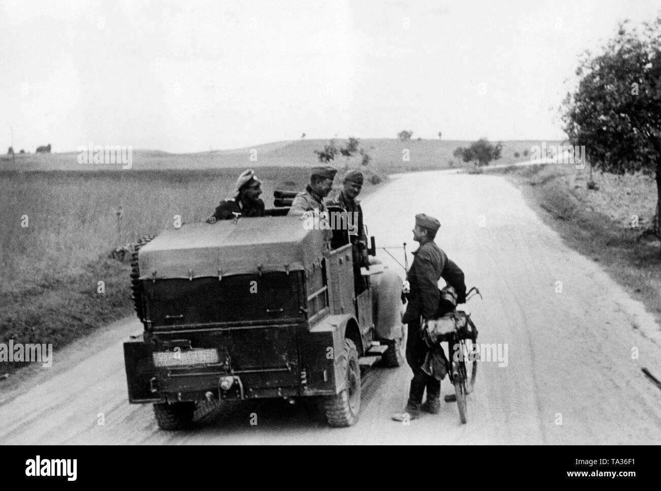 A military vehicle shortly after the beginning of the German-Soviet War. In the center on the vehicle a general of the Wehrmacht, on the right a soldier with bicycle. At Grotke. Photo: war reporter Wiesemann. Stock Photo