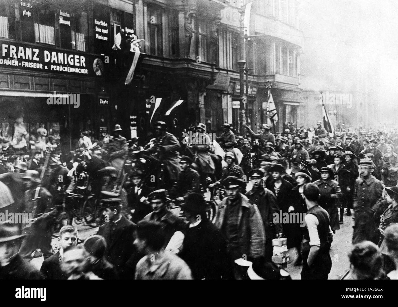 The population of Cologne welcomes the soldiers coming home. These march with the flags of their regiments through the streets of the city. Stock Photo