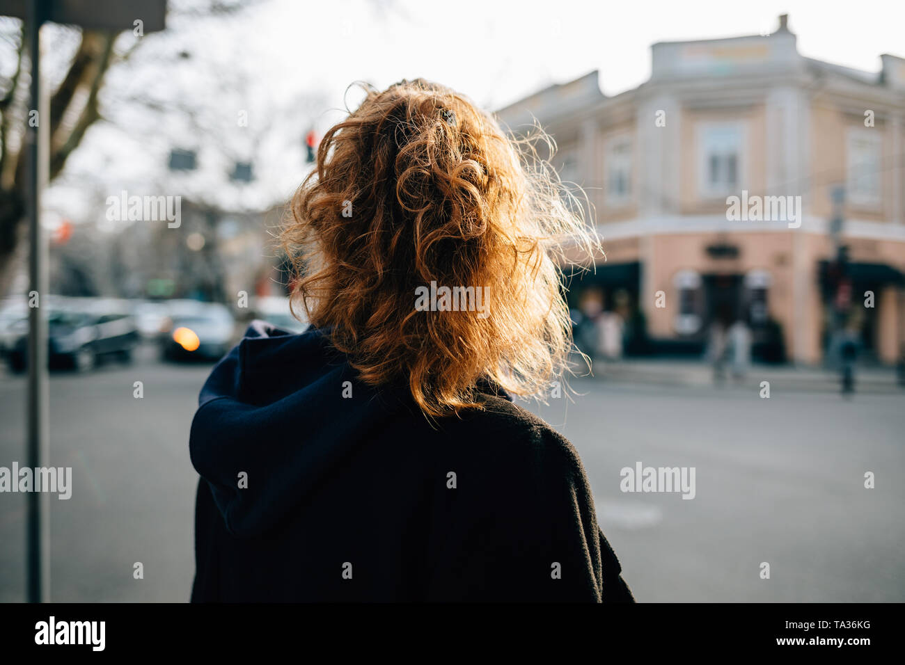 Female With Curly Hair And Ponytail Hairstyle Wearing Black Coat