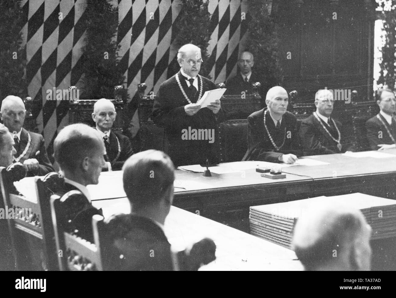 Mayor Karl Scharnagl, who was appointed by the Allies speaks to the 36 city councilmen during the first council meeting in the small meeting room of the Munich Town Hall. On the left, police president Pitzer (?), at right the second mayor and head of the Munich city administration Franz Stadelmayer, later director of the Bavarian Rundfunks. Stock Photo
