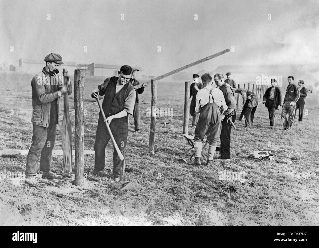 Workers are building a protective fence at the Staaken airfield. Stock Photo