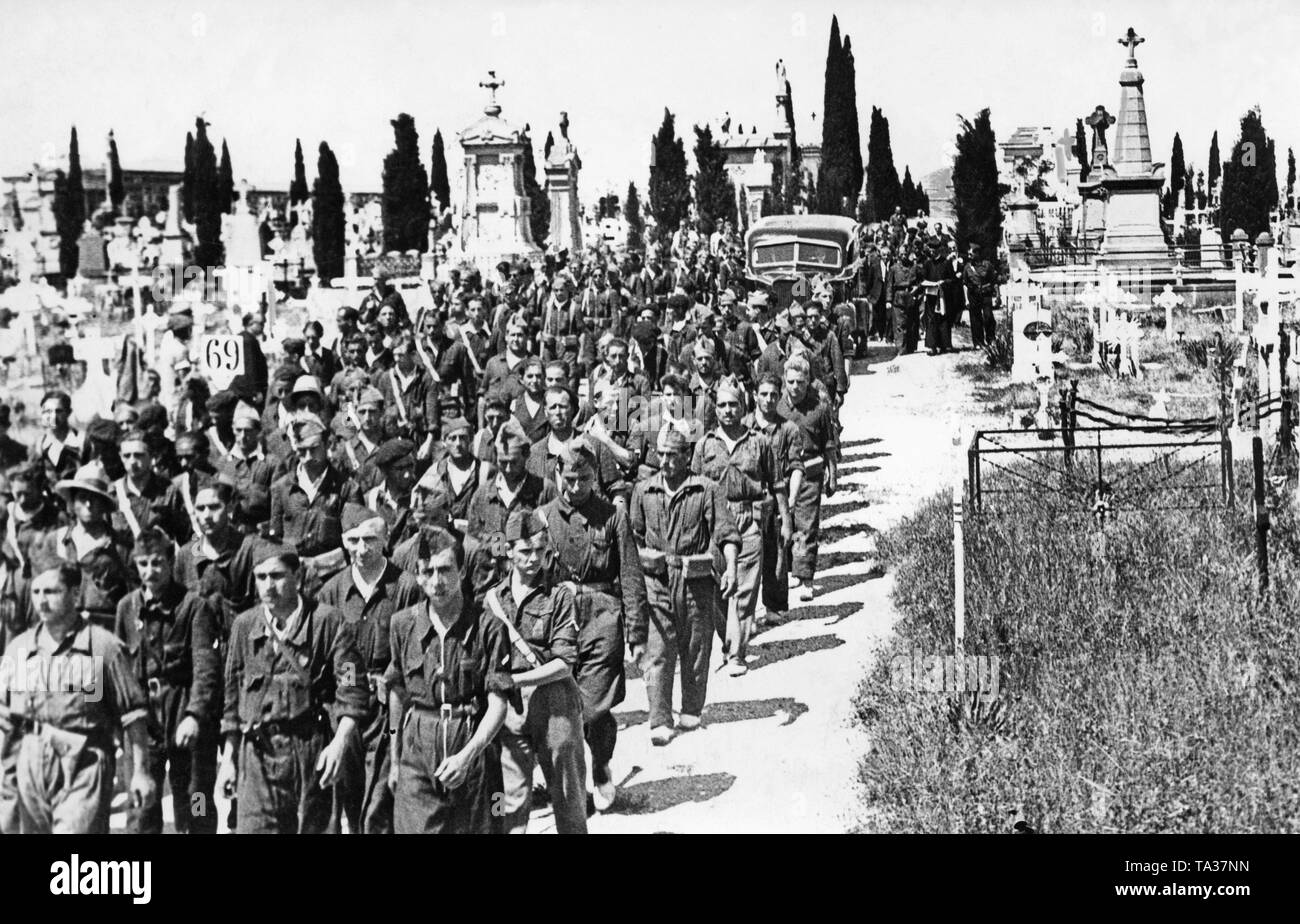 Photo of members of a Fascist militia in the blue shirts of the Falange Espanola (Fascist Party) of Jose Antonio Primo de Rivera (died 1936), who fought on the side of Franco's troops, leaving a cemetery in Zaragoza. Previously, they mourned their first casualties in the Spanish Civil War. Stock Photo
