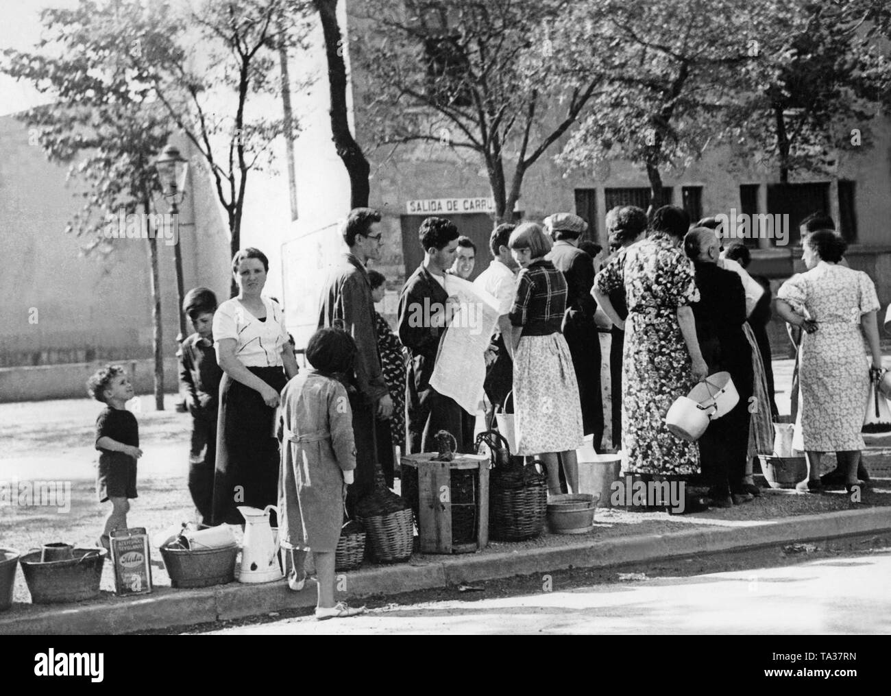 A group of civilians stand in queue at a public well for drinking water. Shortly before the conquest in September the Spanish Nationalist troops succeeded to cut off Sann Sebastian from the water supply. Stock Photo