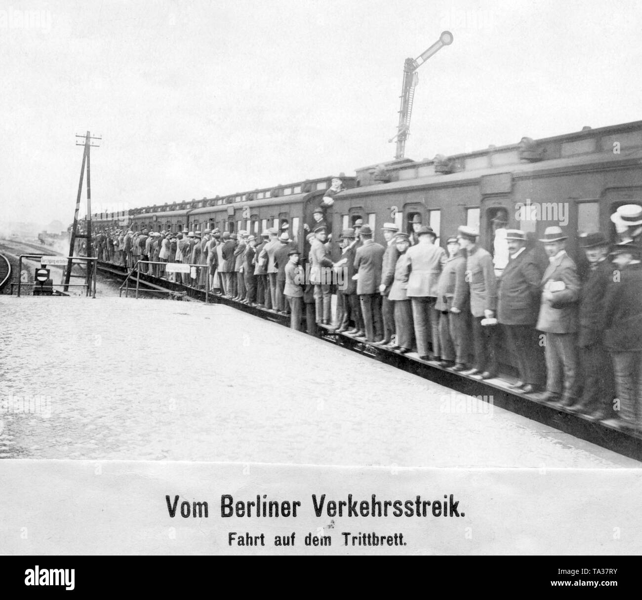 During the traffic strike, only a few trains leave and they are hopelessly overcrowded. The passengers are standing on buffers and footboards to be able to travel. Stock Photo