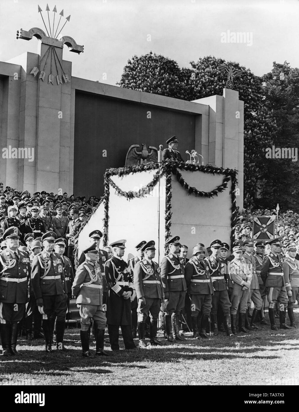Photo of Field Marshal General Hermann Goering (commander-in-chief of the Luftwaffe) on the lectern during a speech on the occasion of a victory parade of the Condor Legion in the Hamburg Moorweide at the Dammtor, on the 30th of May, 1939. In the first row from left: General der Flieger Hugo Sperrle, General der Flieger Hellmuth Volkmann, General of the Cavalry Wilhelm Knochenhauer, General Admiral Conrad Albrecht and Colonel-General Erhard Milch. In the upper left corner of the photo, the symbol of the Spanish Fascist Party, the Falange Espanola (arrows and yoke). Stock Photo