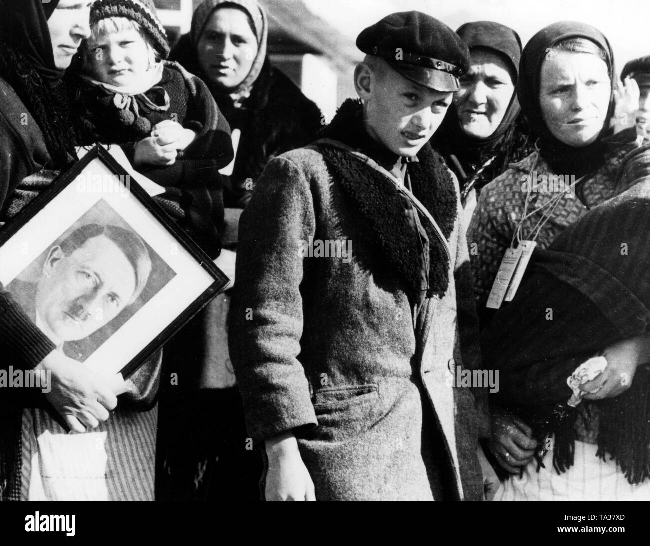 Ethnic German settlers from Bessarabia with a portrait of Adolf Hitler before the SS commission of the Race and Settlement Main Office in the resettlement camp of Galatz. Stock Photo