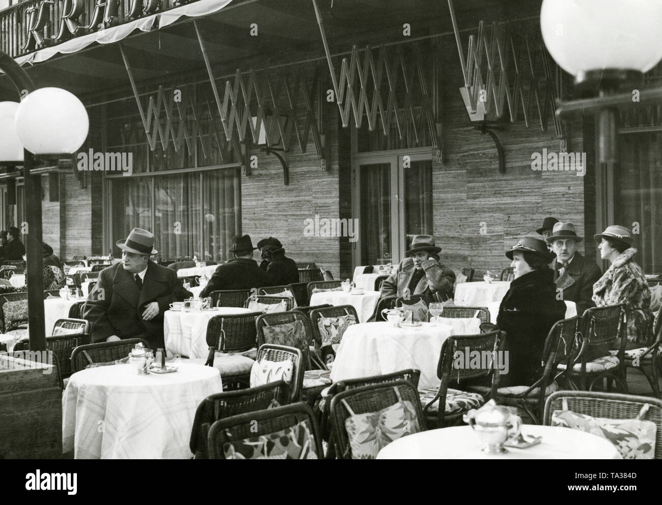 Some guests on the street terrace of the Cafe Kranzler in Berlin. The first  Cafe Kranzler in Berlin was opened in 1825 by Johann Georg Kranzler as a  small pastry shop in